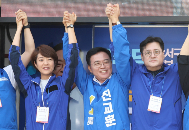 더불어민주당 진교훈 강서구청장 보궐선거 후보의 선거대책위원회가 지난달 28일 오전 화곡역 인근에서 연 선대위 출정식에서 참가자들이 손을 들어올리고 있다. 연합뉴스