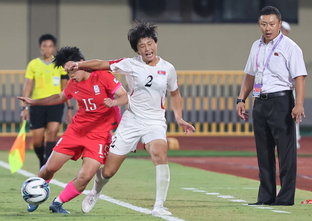 지난달 30일 중국 원저우 스포츠센터 스타디움에서 열린 2022 항저우 아시안게임 여자축구 8강전 한국과 북한의 경기. 후반 북한 리유일 감독이 대한민국 천가람과 북한 리명금의 볼다툼 모습을 바라보고 있다. 연합뉴스