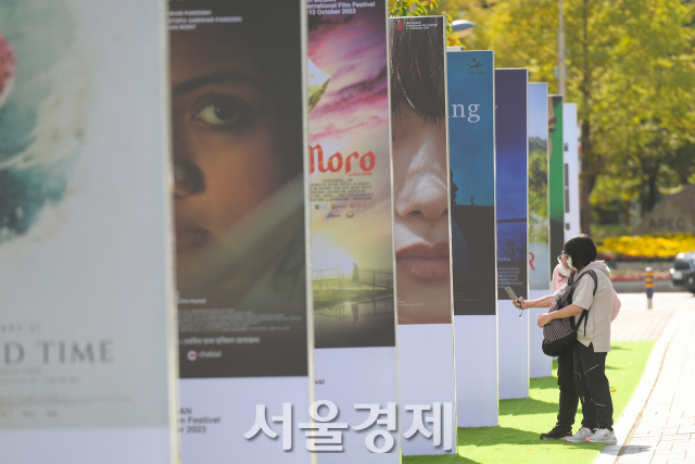 제28회 부산국제영화제(28th BUSAN International Film Festival, BIFF) 개막 당일인 4일 오후 부산 해운대구 영화의 전당에서 시민들이 포스터를 보고 있다. 김규빈 기자