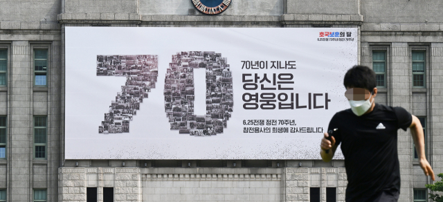 현충일을 하루 앞둔 지난 6월 5일 한 시민이 호국보훈의 달과 정전 70주년을 맞아 교체된 서울 중구 서울도서관 '서울꿈새김판' 앞을 지나고 있다. 오승현 기자