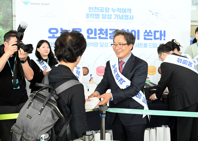 이학재 인천국제공항공사 사장이 4일 인천국제공항 1여객터미널 탑승구 앞에서 열린 인천국제공항 누적 여객 8억 명 달성 기념행사에 참석해 탑승객들에게 선물을 전달하고 있다. 영종도=공항사진기자단 2023.10.04