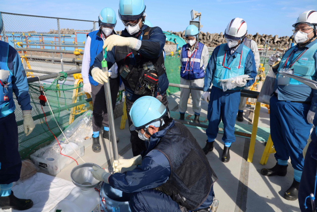 3일(현지시간) 일본 후쿠시마현 오쿠마에서 관계자들이 후쿠시마 제1원자력발전소 오염수의 2차 방류에 앞서 샘플을 채취하고 있다. 일본은 오는 5일부터 오염수의 2차 방류를 개시할 예정이다. 사진=연합뉴스