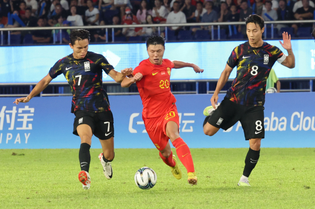 1일 중국 항저우 황룽 스포츠센터 스타디움에서 열린 2022 항저우 아시안게임 남자 축구 8강전에서 정우영과 백승호가 중국 팡하오를 수비하고 있다. 연합뉴스