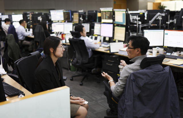 6일 서울 중구 하나은행 딜링룸에서 딜러들이 업무와 관련한 대화를 나누고 있다. 연합뉴스