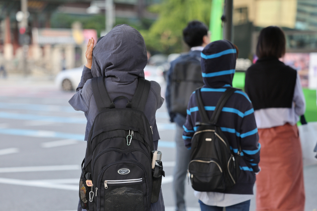 쌀쌀한 가을 날씨를 보인 5일 오전 서울 종로구 광화문네거리에서 외투와 긴팔 옷을 입은 시민들이 횡단보도 신호를 기다리고 있다. 연합뉴스