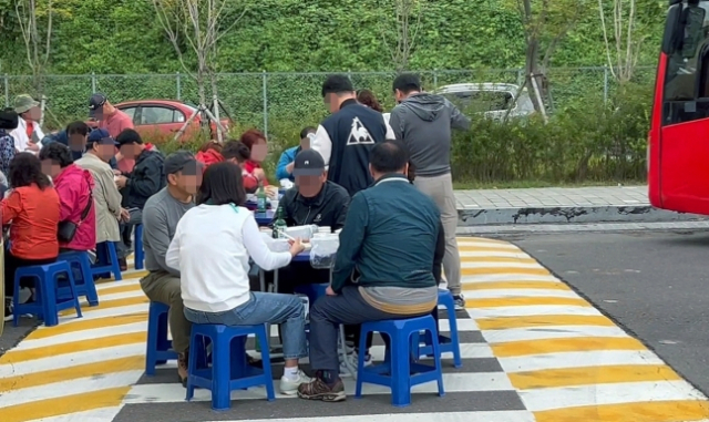 고속도로 휴게소에서 단체 관광객들이 술판을 벌이고 있다. 연합뉴스