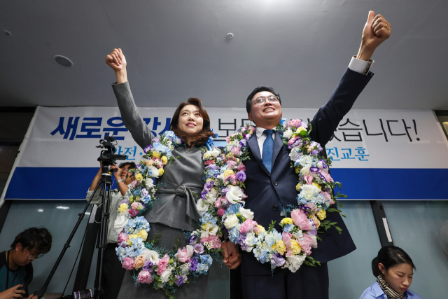 진교훈(오른쪽) 더불어민주당 강서구청장 보궐선거 후보가 11일 강서구 마곡동 캠프사무실에서 당선이 확실시되자 배우자와 함께 꽃목걸이를 걸고 기뻐하고 있다. 연합뉴스