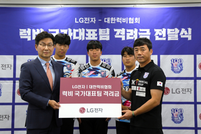 김영락(앞줄 왼쪽) LG전자 한국영업본부장이 11일 대한상의 소재 대한럭비협회 대회의실에서 이명근(앞줄 오른쪽) 럭비 국가대표팀 감독에게 격려금을 전달한 뒤 대학 럭비부 선수들과 함께 기념사진을 촬영하고 있다. 사진 제공=LG전자