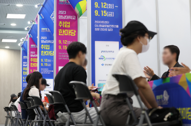 지난달 12일 경북 경산시 영남대학교 천마아트센터에서 취업을 희망하는 대학생들이 취업 정보를 알아보고 있다. 연합뉴스