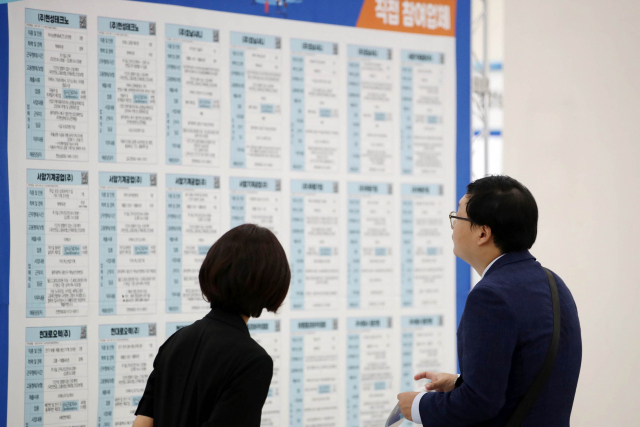 지난달 19일 광주 전남대에서 열린 일자리 박람회의 한 참가자가 채용정보판을 보고 있다. 연합뉴스