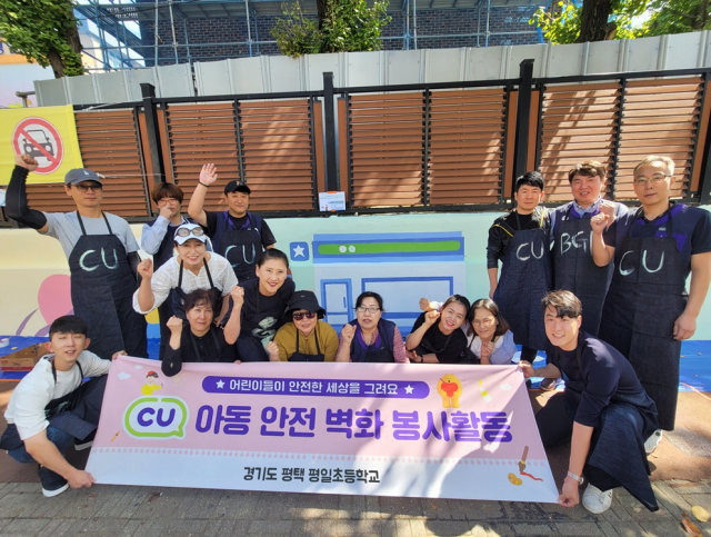 BGF임직원들과 CU가맹점주 등이 경기도 평택시 평일초등학교에서 아동 안전 벽화 그리기 봉사활동 후 기념촬영을 하고 있다. 사진 제공=BGF리테일