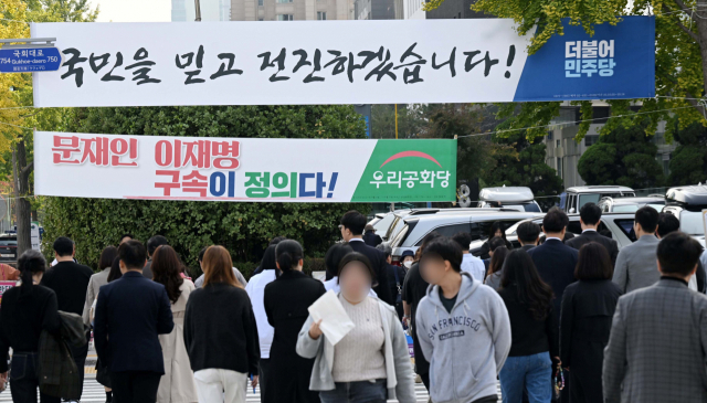 정당 현수막들이 걸려 있는 국회 앞 길에서 시민들이 걷고 있다. 권욱 기자