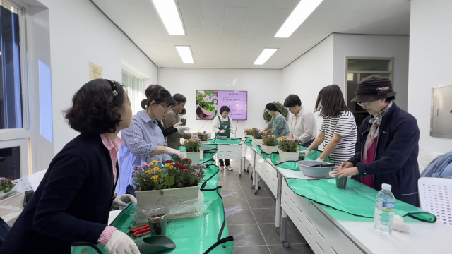 가드닝 프로그램에 참여한 주민들이 집안을 화사하게 꾸며줄 국화 화분을 만들고 있다. 사진=마포구청