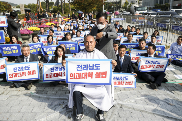 지난 18일 서울 용산 대통령실 앞에서 열린 전라남도 의과대학 신설 촉구대회에서 더불어민주당 김원이 의원이 삭발을 하고 있다. 연합뉴스