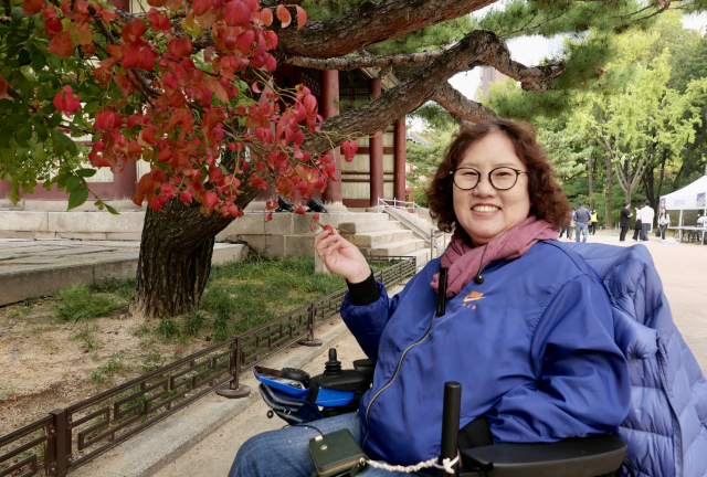 전윤선 작가가 가을을 맞은 덕수궁을 여행하며 환하게 웃고 있다.