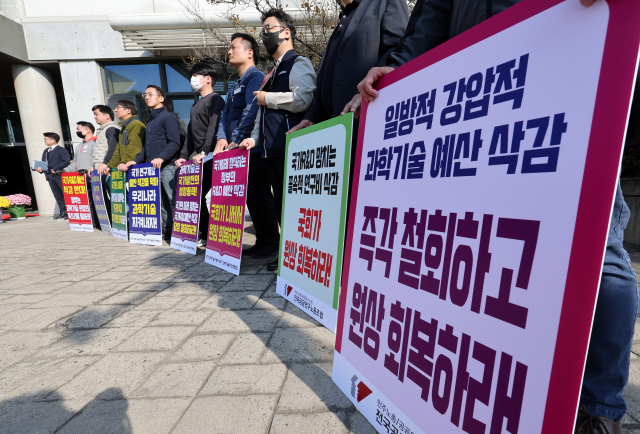 24일 대전 한국전자통신연구원(ETRI)에서 열린 과학기술정보방송통신위원회 국정감사 시작 전 전국공공연구노동조합 관계자들이 R＆D 예산 삭감 등에 항의하는 팻말을 들고 있다. 연합뉴스