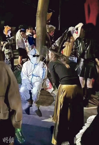 중국 상하이 핼러윈 축제에서 방역요원'다바이'로 분장한 이가 마녀로 분장한 이의 코를 면봉으로 찌르는 시늉을 하고 있다. 사진=연합뉴스, 홍콩 명보 캡처