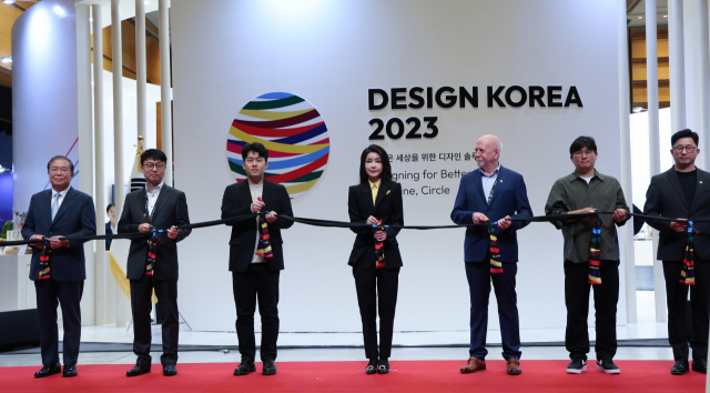 김건희(가운데) 여사가 1일 서울 강남구 코엑스에서 열린 ‘디자인 코리아 2023’ 개막식에서 주요 참석자들과 함께 축하 세리머니로 묶인 스카프의 매듭을 풀고 있다. 연합뉴스