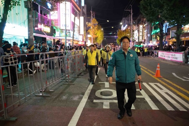 박강수 마포구청장(오른쪽)이 29일 새벽, 홍대 클럽거리 일대에 인파밀집 혼잡을 해소하기 위해 도로 양방향 차량을 통제하여 확보한 보행로를 살펴보고 있다. 사진 제공=마포구청