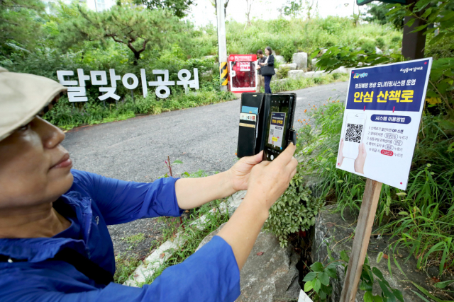서울 성동구 달맞이 공원에서 산책로 범죄예방시스템을 이용하는 주민의 모습. 사진=성동구청 제공
