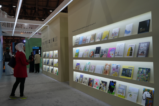 아랍인 여성이 한국관에 전시된 책들을 주의깊게 살피고 있다.