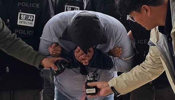 70대 택시 기사를 살해하고 태국으로 도주한 혐의를 받는 40대 남성이 지난달 24일 오전 충남 아산경찰서로 압송되고 있다. 연합뉴스