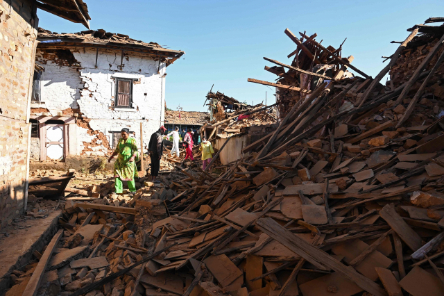 3일 네팔 북서부 지역을 덮친 강진으로 사상자가 급증하고 있는 가운데 피해가 발생한 한 마을에서 주민들이 폐허가 된 주택가를 걷고 있다. AFP연합뉴스