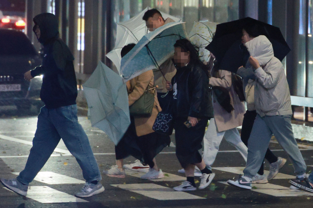 6일 저녁 거센 비바람이 부는 서울 홍대입구역 인근에서 시민들이 강풍을 맞으며 걸어가고 있다. 연합뉴스