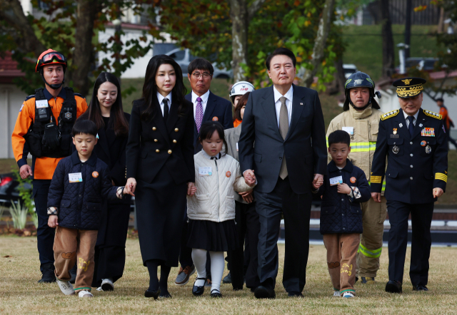 윤석열 대통령과 김건희 여사가 9일 서울 용산어린이정원 잔디마당에서 열린 제61주년 소방의 날 기념식에 순직 소방관 자녀들의 손을 잡고 입장하고 있다. 연합뉴스