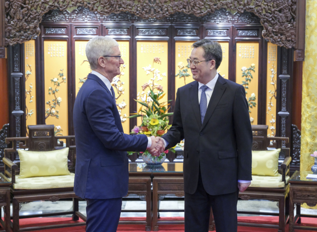 팀 쿡 애플 최고경영자(CEO)가 19일 베이징에서 딩쉐샹 중국 부총리를 만나 악수하고 있다. 신화연합