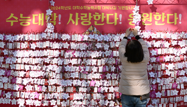 2024학년도 대학수학능력시험을 나흘 앞둔 12일 오후 서울 종로구 조계사에서 학부모가 자녀의 수능 대박을 기원하는 응원 문구를 매달고 있다. 권욱 기자