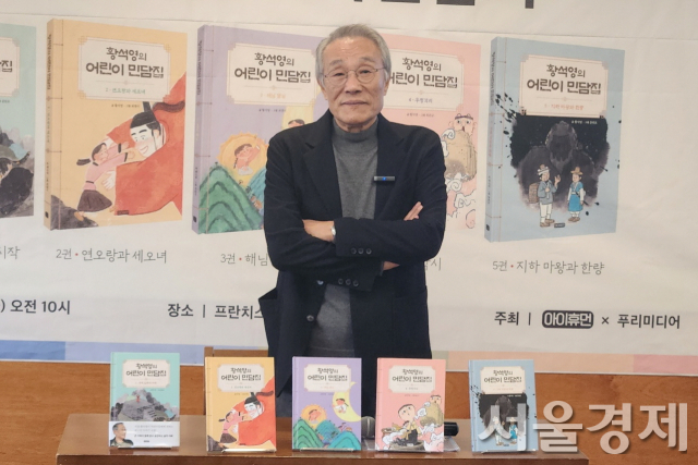 황석영 작가가 14일 자신의 ‘황석영의 어린이 민담집(5권)’을 배경으로 포즈를 취하고 있다. 최수문 기자