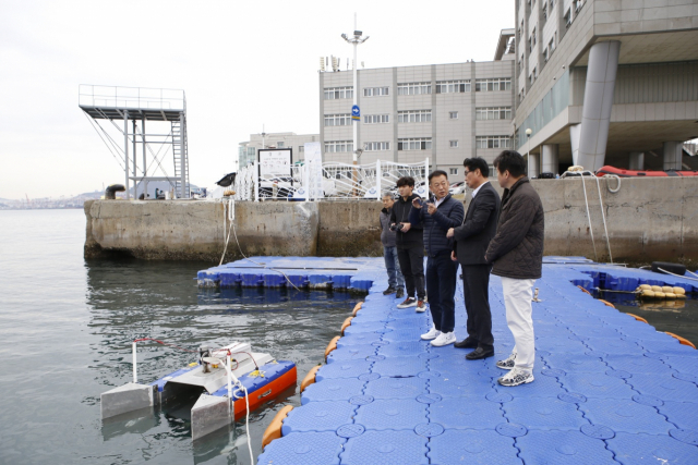 한국해양대학교를 찾은 신종석(오른쪽 두번째) 부산지방조달청장이 코아이가 개발한 ‘무선 자항 유출유 회수 로봇’에 대한 설명을 듣고 있다. 사진제공=부산조달청