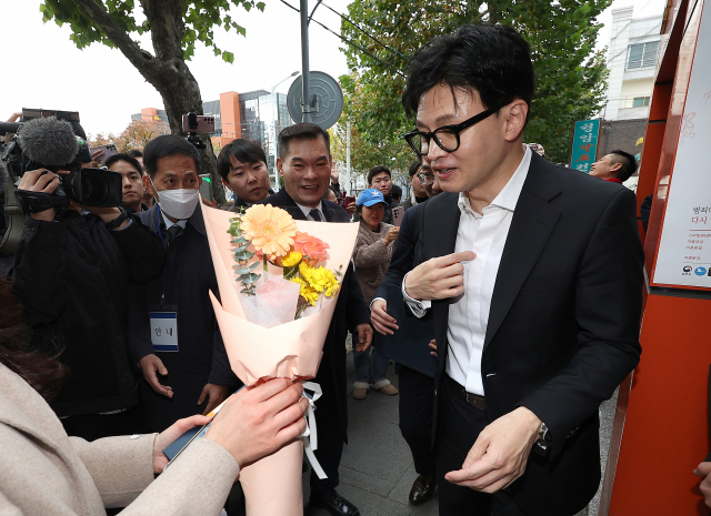 한동훈 법무부 장관이 17일 대구 수성구 스마일센터 방문 중 한 시민에게 꽃다발을 받고 있다. 연합뉴스