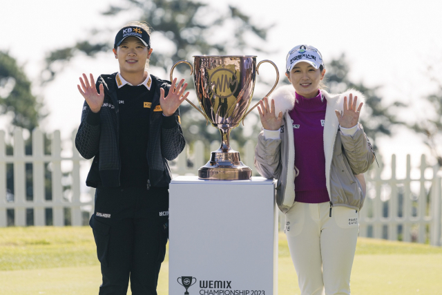 방신실(왼쪽)과 박현경이 17일 위믹스 챔피언십 트로피 앞에서 손 인사 포즈를 취하고 있다. 사진 제공=대회조직위