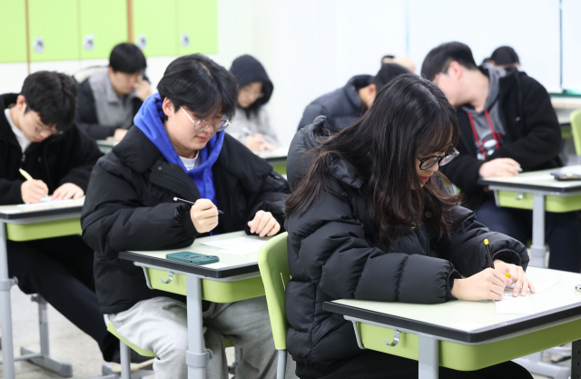 2024학년도 대학수학능력시험 다음날인 17일 오전 서울 시내 한 고등학교에서 고3 학생들이 가채점 표를 작성하고 있다. 연합뉴스