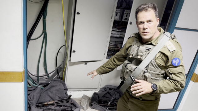 15일(현지 시간) 가자지구 최대 의료기관인 알시파 병원 MRI 센터에서 한 이스라엘 군인이 수류탄과 총기류 등 무기를 가리키고 있다. 로이터연합뉴스