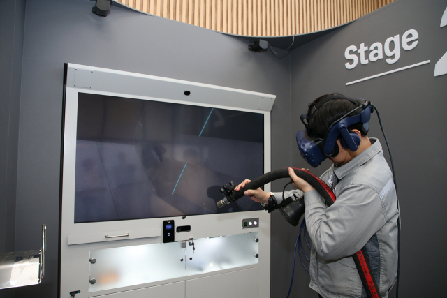 한화오션 직원이 거제사업장 내부에 위치한 VR도장교육센터에서 VR 블라스팅 직무훈련을 하고 있다. 사진제공=한화오션