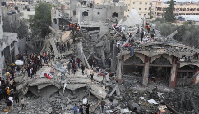 22일(현지시간) 가자지구 라파에서 주민들이 이스라엘 공습으로 파손된 건물에서 구조 작업을 펼치고 있다. 연합뉴스