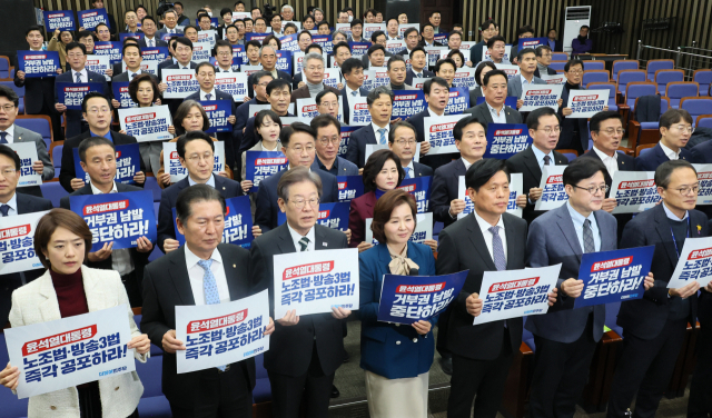 더불어민주당의 이재명(앞줄 왼쪽 세 번째) 대표를 비롯한 의원들이 23일 오후 국회에서 열린 의원총회에서 노조법과 방송 3법 즉각 공포를 촉구하는 구호를 외치고 있다. 연합뉴스