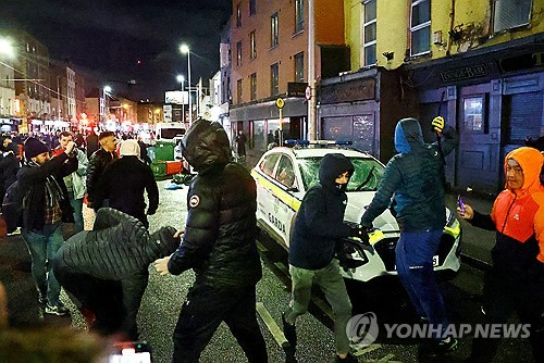 23일(현지시간) 아일랜드 더블린 시내에서 시위대가 경찰차를 부수고 있다. 로이터·연합뉴스