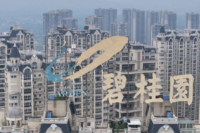 중국 장수성 전장에 위치한 부동산 개발업체 비구이위안의 로고 뒤로 건설 중인 주택단지들이 보인다. AFP연합뉴스