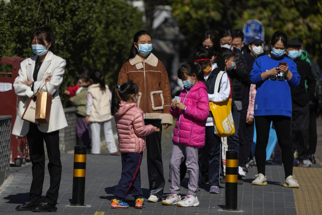 코로나19가 확산하던 지난해 10월 중국 베이징의 한 아파트 단지 외곽에 마련된 코로나19 검사소에 마스크를 쓴 방문자들이 줄지어 차례를 기다리고 있다./AP연합뉴스