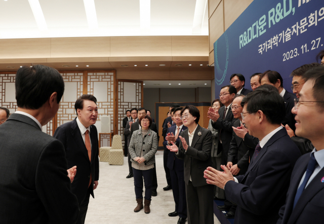 윤석열 대통령이 27일 서울 용산 대통령실 청사에서 열린 국가과학기술자문회의 민간위원 오찬 간담회에서 참석자들과 기념촬영을 마친 뒤 대화하고 있다./연합뉴스