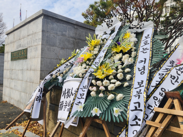 경남교육청 정문 앞에 양산의 한 초등학교 교장의 갑질 및 교육청의 미비한 대처를 비판하는 조화가 설치돼 있다. 창원=박종완 기자