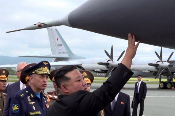 김정은 북한 국무위원장이 지난 9월16일(현지시간) 러시아 블라디보스토크 크네비치 공군기지를 방문해 미그 31 전투기에 장착된 극초음속 미사일 ‘킨잘’에 직접 손을 갖다 대고 있다. AFP연합뉴스