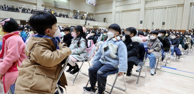 지난 3월 2일 오전 서울 강동구 강빛초등학교에서 열린 입학식에서 한 1학년 학생이 뒤에 앉은 같은 반 친구들을 보고 있다. 연합뉴스