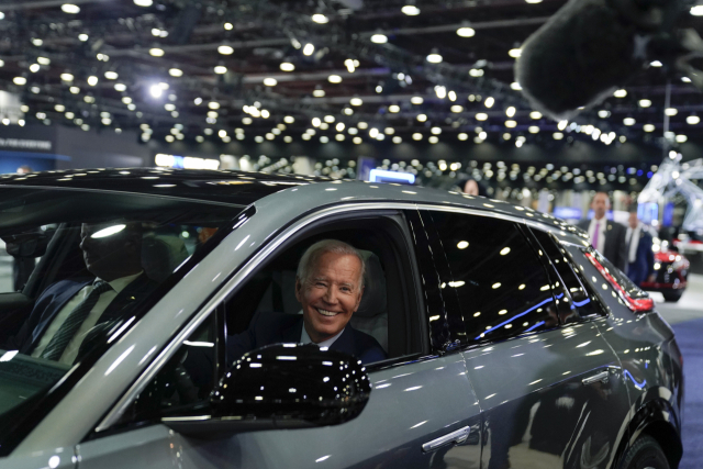 조 바이든 미국 대통령이 10월 미국 디트로이트에서 열린 오토쇼에서 미국산 자동차에 올라타 웃고 있다. AP연합뉴스