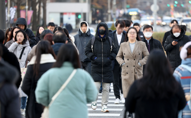 지난달 28일 서울 광화문광장에서 시민들이 두꺼운 옷차림을 한 채 걸어가고 있다.연합뉴스