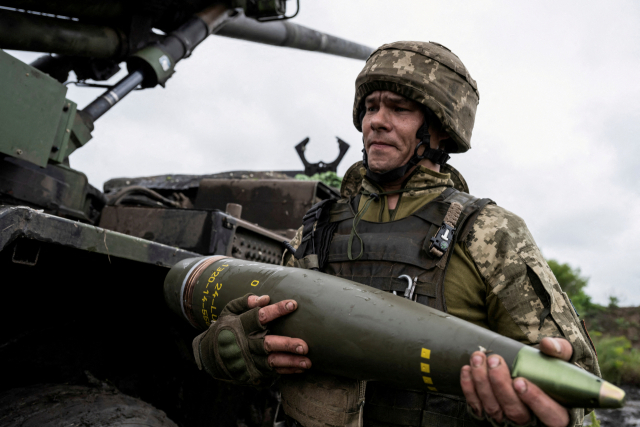 우크라이나에서 한 병사가 포탄을 옮긱고 있다. 로이터연합뉴스